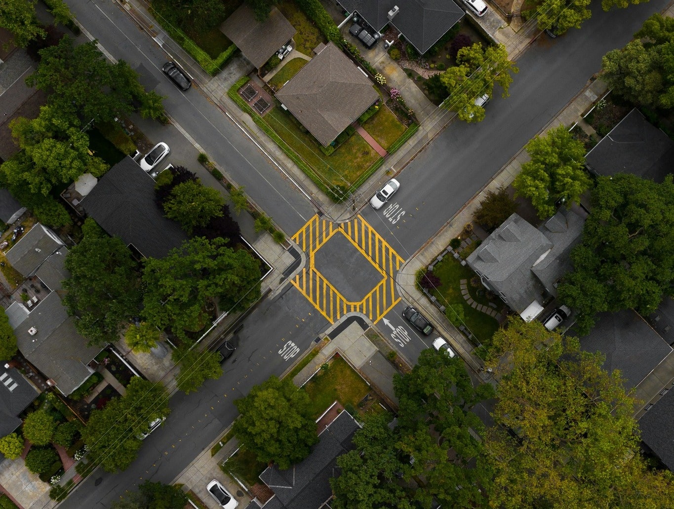 an aerial view of a street intersection with a yellow triangle